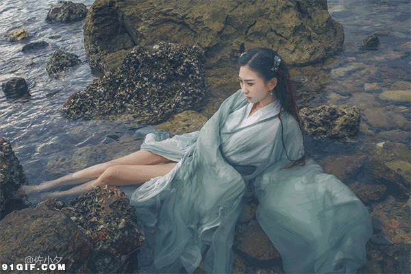 长袍女子泡清澈的河水图片
