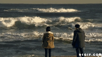 男女观赏海上浪花图片