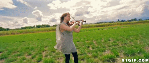 在草原拉小提琴的少女图片