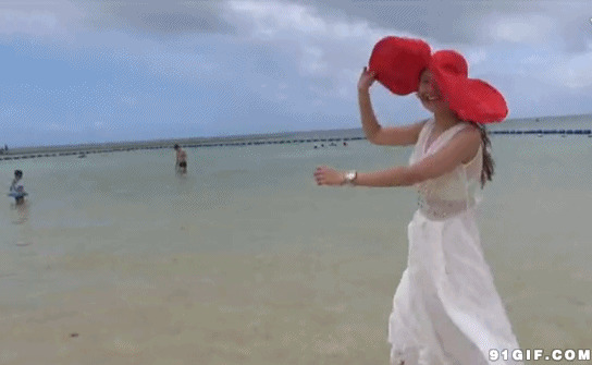 戴大红帽女子在海边图片
