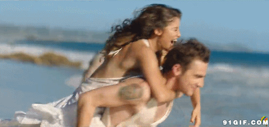 男人背着幸福的女孩在沙滩图片