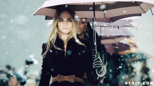 雪天打伞的冷艳女模特图片