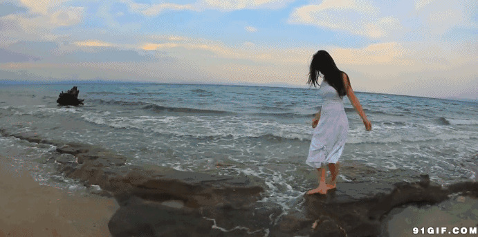 白裙赤脚女海边踏浪图片