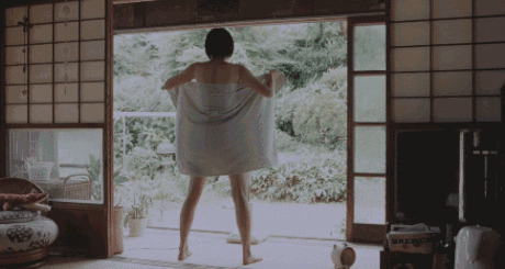 寒冷的天气女神站在窗边解开自己的浴巾动态图片