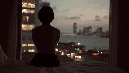 安静的女孩子坐在窗边看夜景动态图片