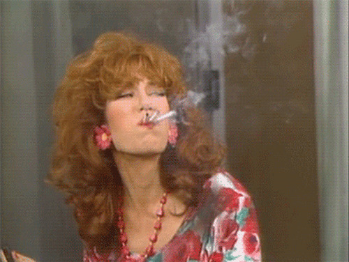 卷发女人嘴里抽三根烟GIF图片:抽烟