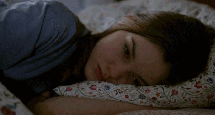 伤心的女孩趴在床上辗转难眠GIF动态图