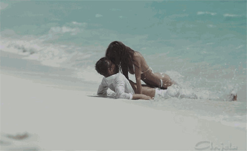 情侣躺在海边的沙滩上亲吻GIF动态图:亲吻