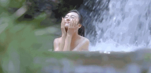 女神在瀑布下的水里尽情的洗澡GIF动态图