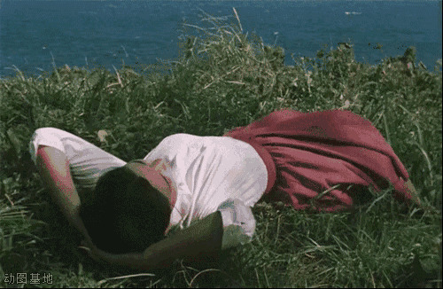 女孩穿着裙子躺在河边的草地上睡觉gif图片:睡觉