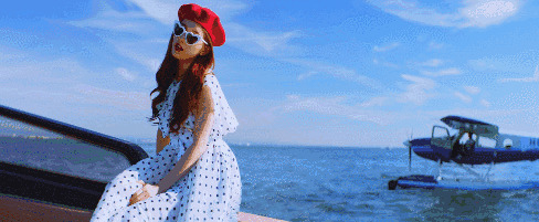 姑娘戴着红色的帽子坐在船头唱歌GIF动态图:唱歌