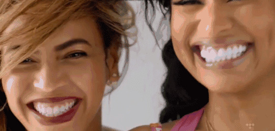 两个女人面对面微笑露出大白牙GIF动态图