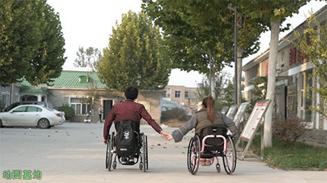 夫妻坐轮椅手牵手GIF图片