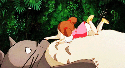 卡通小女孩趴在龙猫的肚子上玩耍gif图片