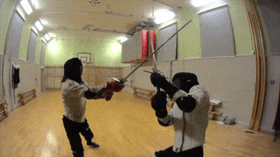 两个戴着面罩的男子在房间里练习击剑gif图片