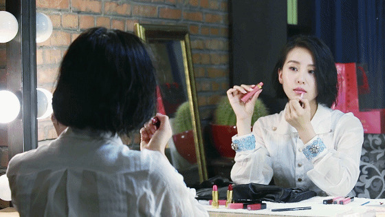 女孩子坐在镜子前精心的化妆gif图片