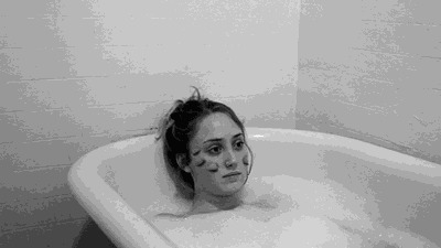 脸上长满眼睛的女孩躺在浴缸里泡澡gif图片