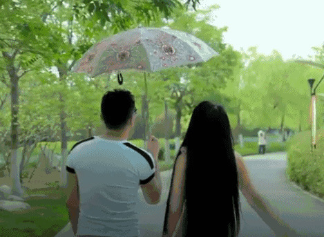 情侣在公园里打着雨伞散步gif图片:情侣