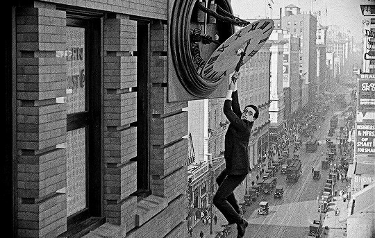 搞笑的卓别林在高楼上拽住表针gif图片:卓别林