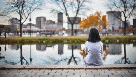 伤心的女孩独自一人坐在河边深思gif图片