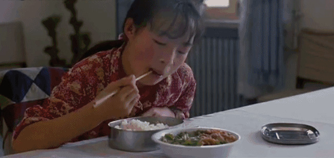 饥饿的小女孩趴在桌子上疯狂的吃放gif图片