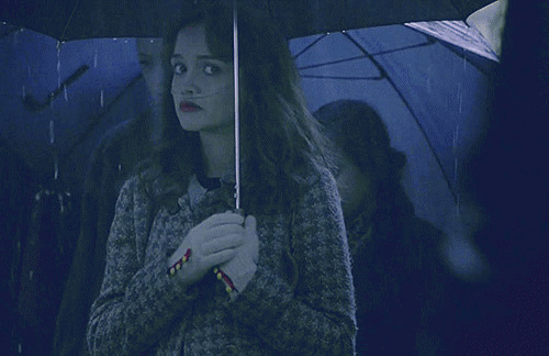 漂亮的女孩在雨中打着伞眼睛偷偷的瞟你GIF图片