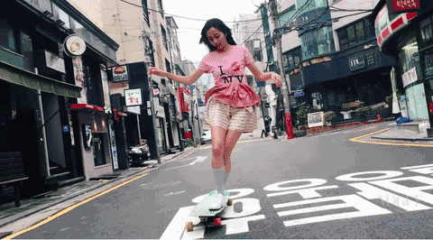 潇洒的女孩在马路上玩滑板gif图片
