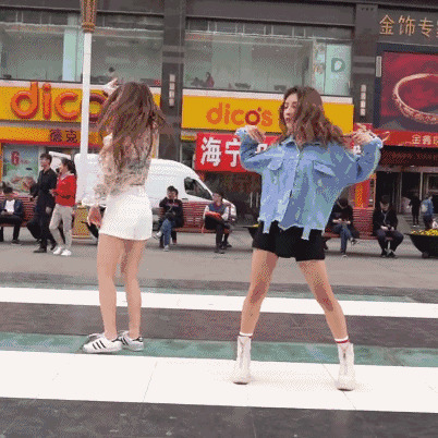 两个女孩站在大街上跳舞gif图片